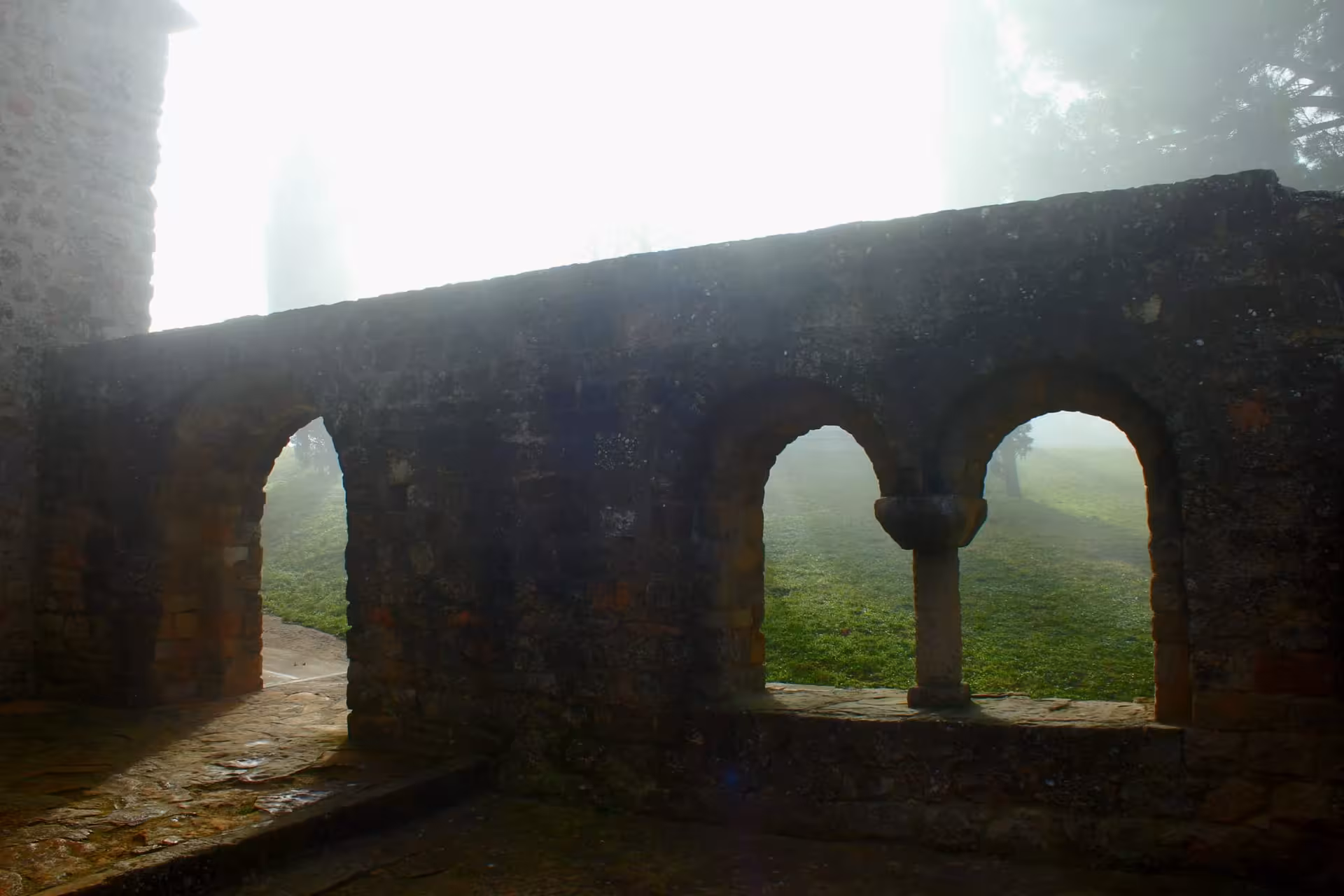 Stone arches at Santa Cecilia de Montserrat in morning mist on private Montserrat scenic hiking tour