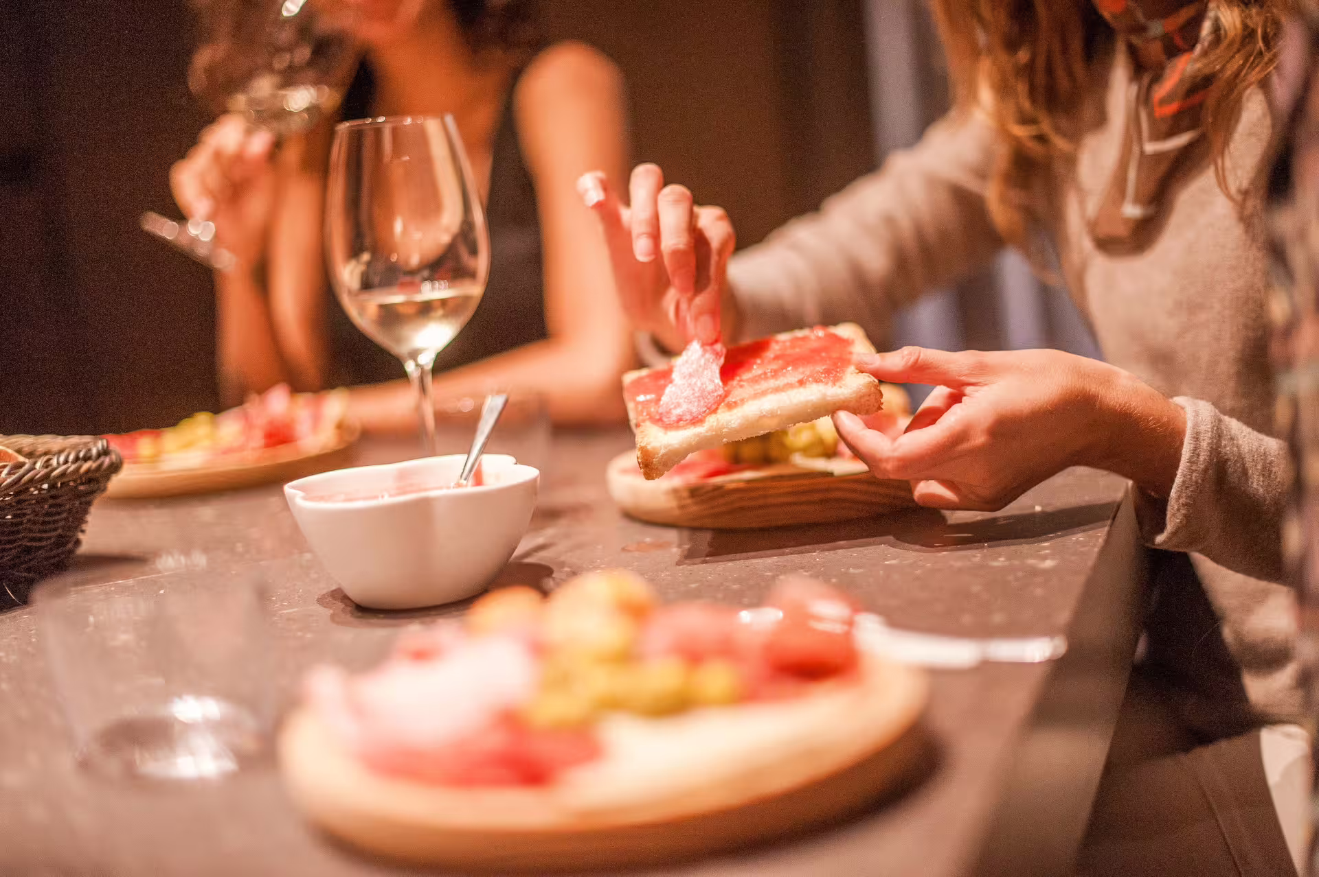 Guests savoring tapas with wine, showcasing a cozy dining experience on the Extended Montserrat tour with cogwheel train.