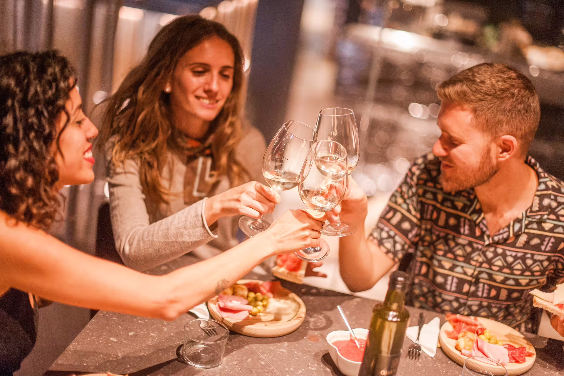 Group enjoying tapas and wine toasting at a cozy table during the Extended Montserrat tour with cogwheel train experience.