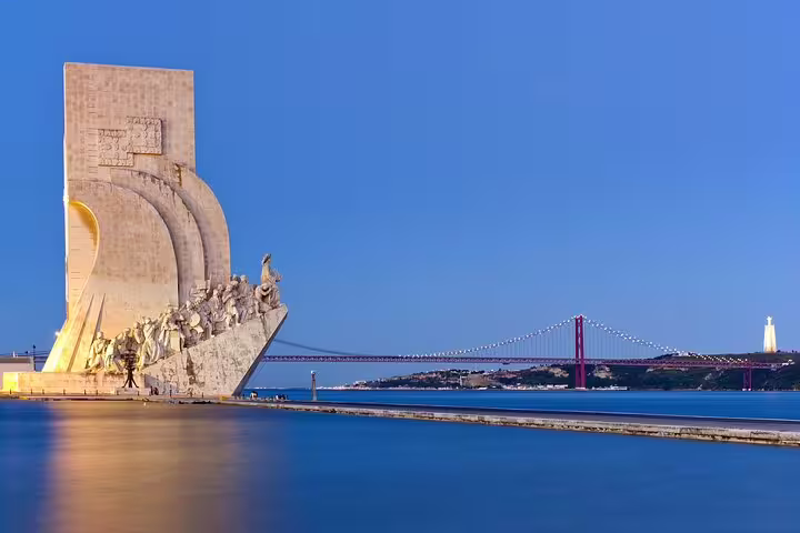 Monument of Discoveries in Belem, Lisbon, with iconic bridge and river view, perfect for historical and cultural day tours.