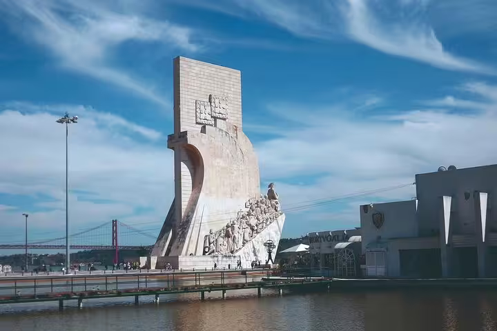 Monument of Discoveries in Lisbon with detailed sculptures, set against a vibrant sky, perfect for a private city tour.