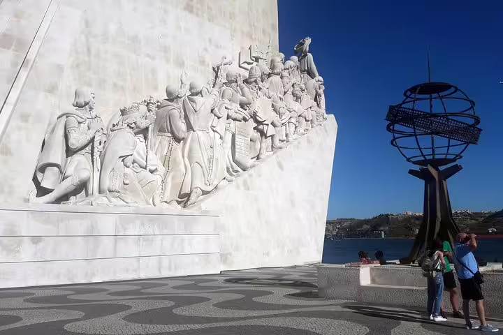 Monument of Discoveries in Lisbon, showcasing detailed sculptures against a clear blue sky, included in World Heritage Tour.