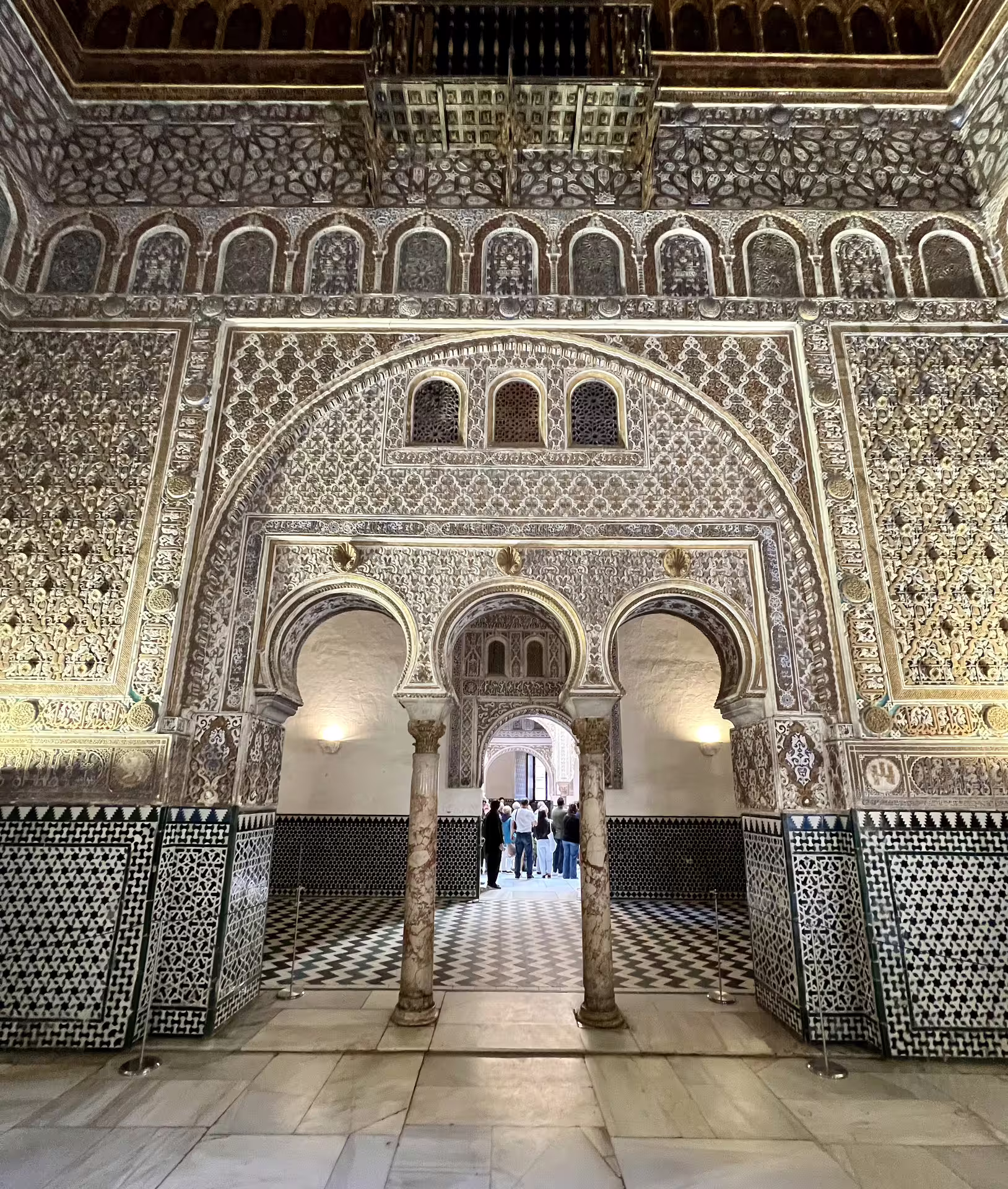 Intricate Moorish arches and ornate tilework inside the Royal Alcazar of Seville, perfect for a private guided tour experience.