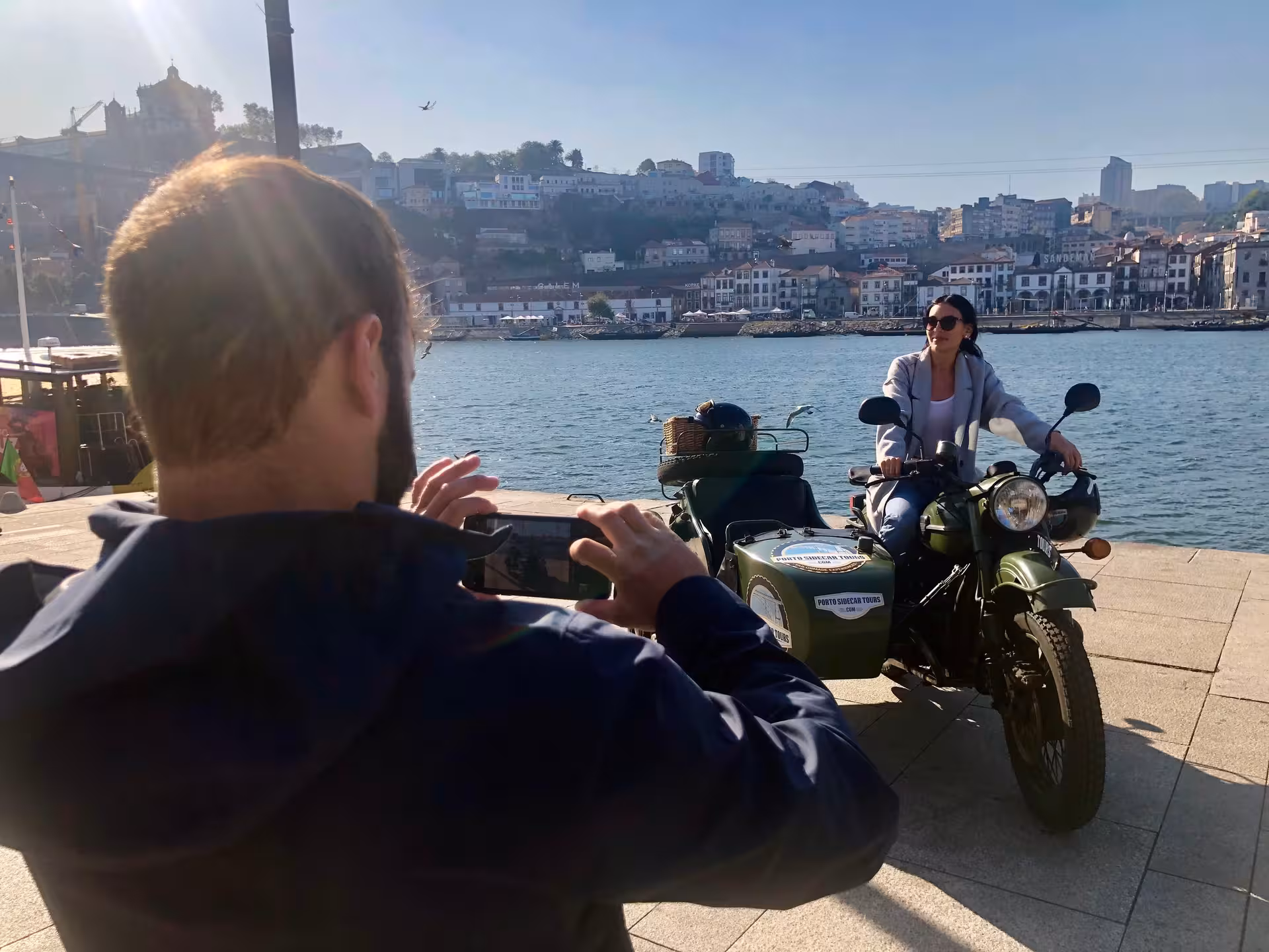 Morning Tour Porto sidecar photo stop by the Douro River, with Ribeira skyline and vintage motorcycle