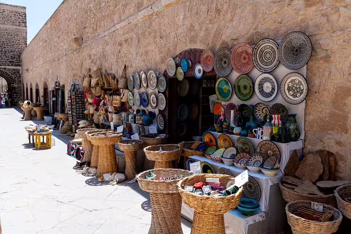 Traditional Moroccan souk stall with colorful ceramics and woven baskets, Ourika Valley day trip from Marrakech