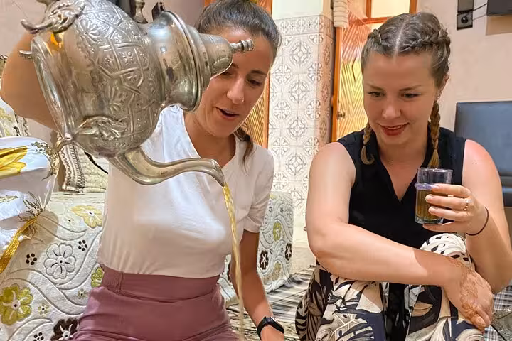Guests enjoying traditional Moroccan tea pouring experience during the Cooking Class with Yassine & Mom.