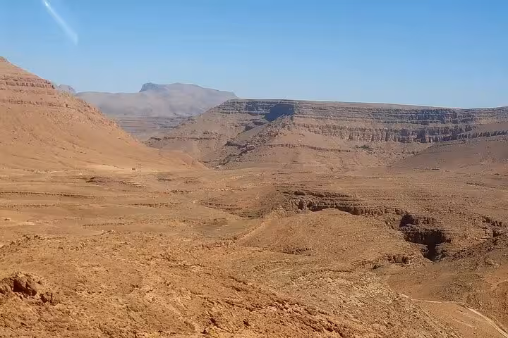 Vast rocky landscape of Morocco's desert terrain, showcasing dramatic cliffs and valleys on a tour from Fes to Marrakech.