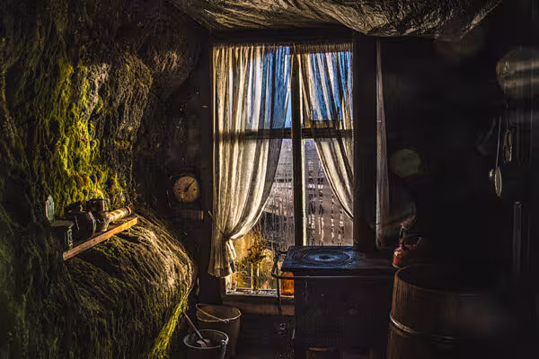 Moss-covered cave wall with vintage decor and window view, ideal setting for a standard cave tour adventure.