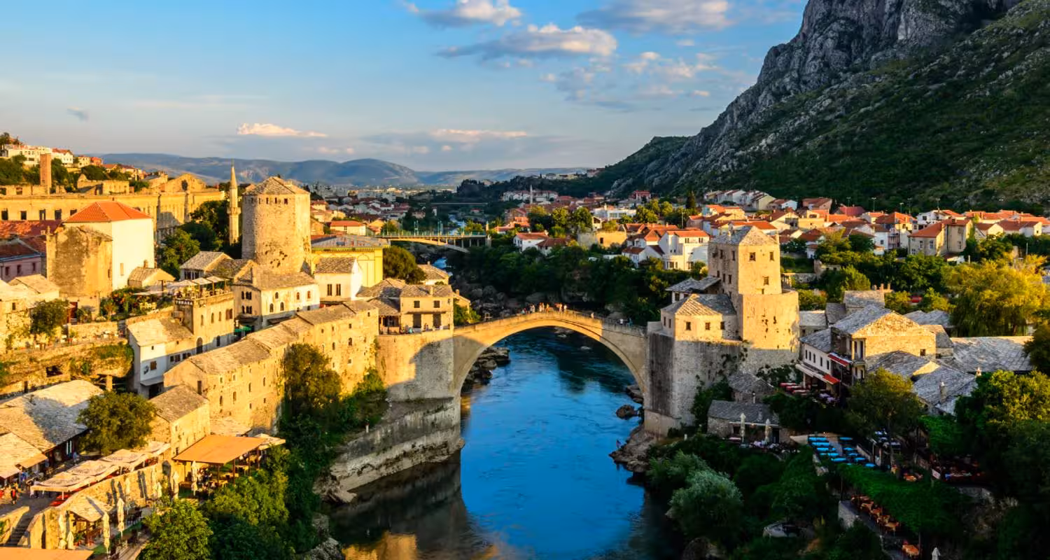Historic Mostar Bridge over the Neretva River at sunset, a must-see on a Balkan experience tour.