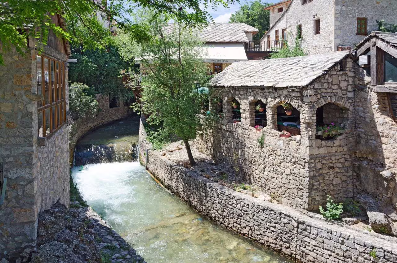 Stone houses and riverside walkway in Mostar old town, day trip on Croatia 11-day self-drive tour