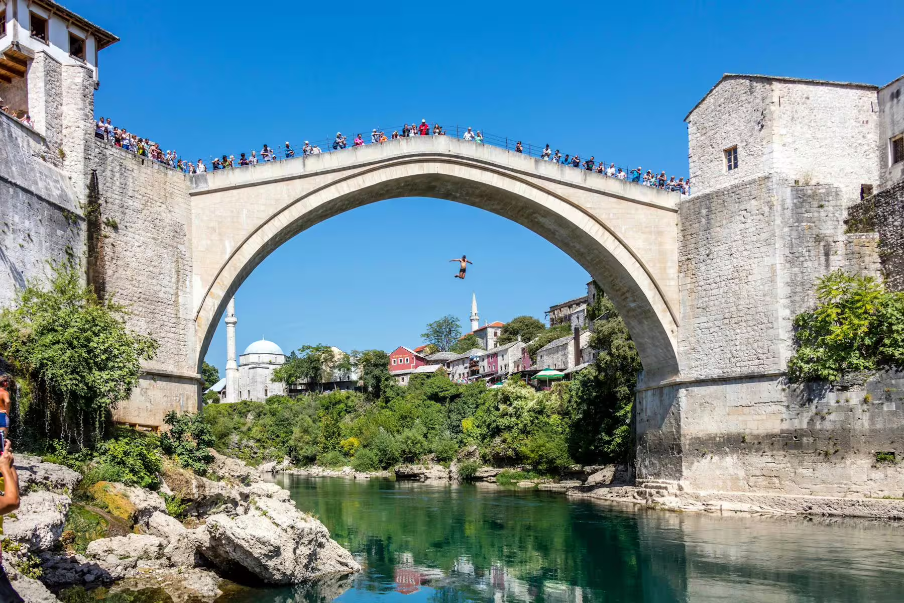 Mostar Old Bridge Stari Most over Neretva River with diver, highlight on day trip from Makarska Riviera