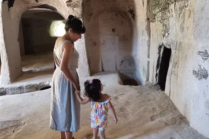 Mother and child exploring a Cappadocia rock-cut cave room, family-friendly stop on private full-day tour
