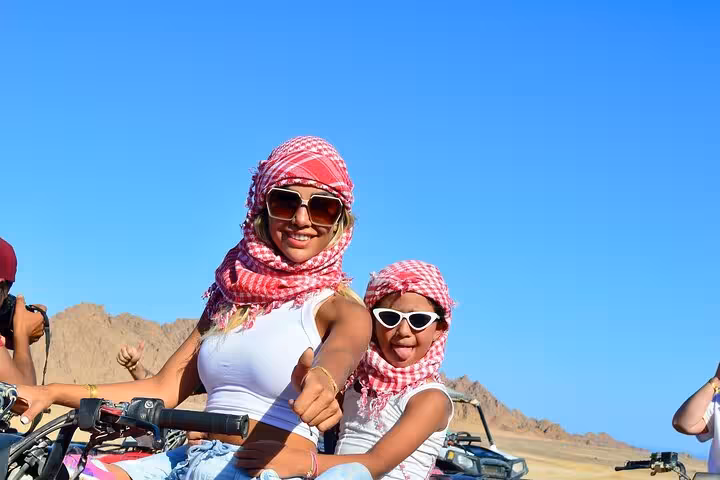Mother and child on a private VIP quad bike in Sharm El Sheikh desert, wearing scarves and sunglasses