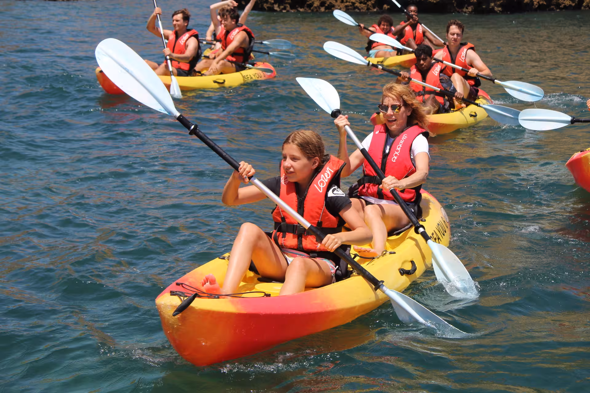 Mother and daughter paddling tandem kayak on Lagos Algarve coast, enjoying an active guided sea adventure tour