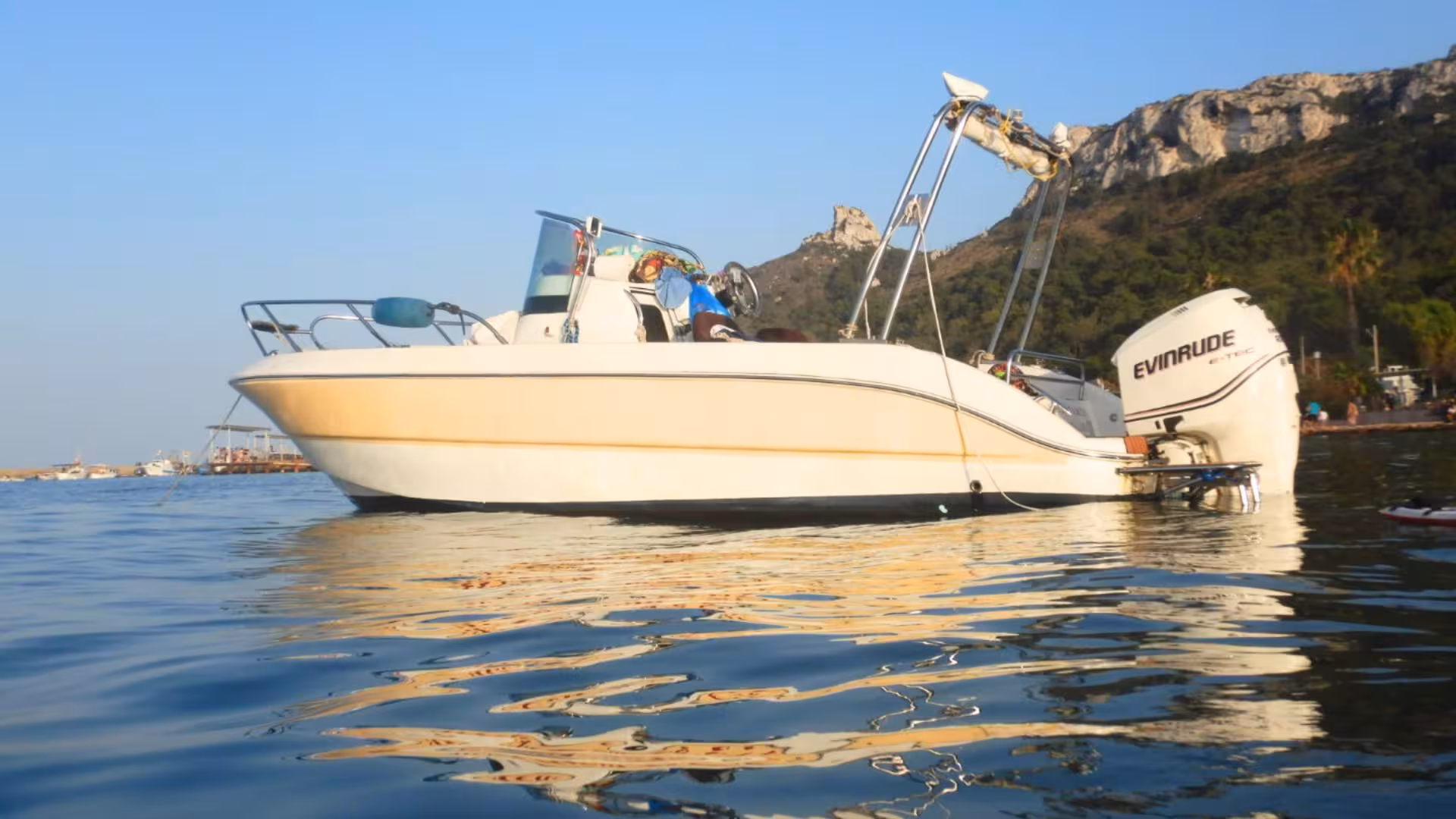 White motorboat anchored in Golfo degli Angeli, offering a scenic view of Cagliari's coastal adventure.