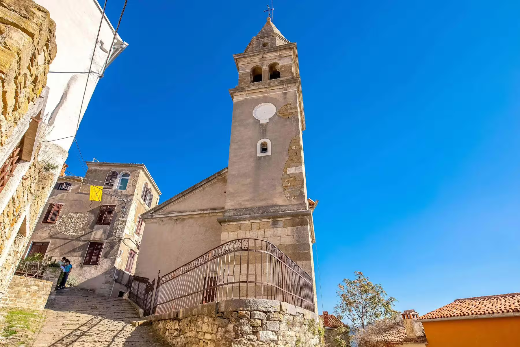 Motovun church bell tower above stone street in Istria, stop on half-day truffle and local brandies tour