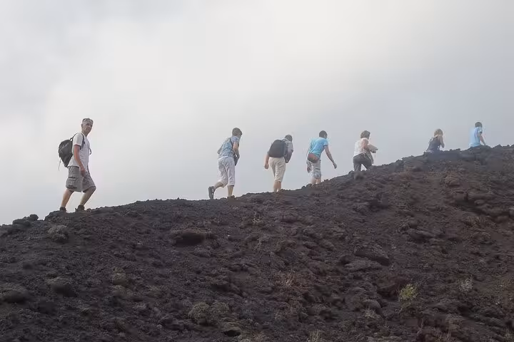 Hikers ascending the rocky paths of Mount Etna, capturing the thrill and challenge of a guided trekking experience.