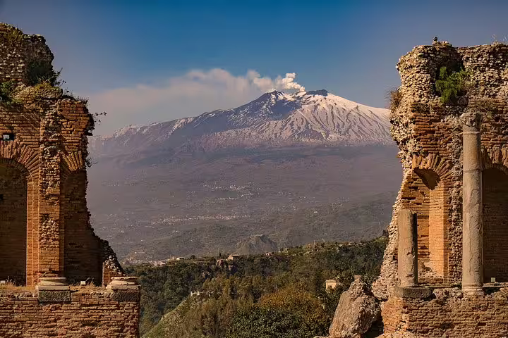 Smoking Mount Etna seen from ancient Greek Theatre of Taormina, iconic stop on private tour from Cefalù in Sicily