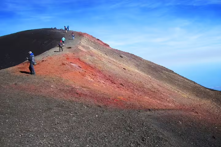 Small group hiking along colorful volcanic ridge on Mount Etna during private tour from Cefalù with Taormina visit