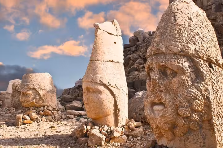 Sunrise view of giant stone heads on Mount Nemrut summit, highlight of Commagene 2-day 1-night tour from Istanbul by plane