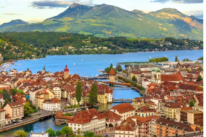 Stunning aerial view of Lucerne's vibrant old town, serene Lake Lucerne, and majestic Mount Pilatus in the distance.