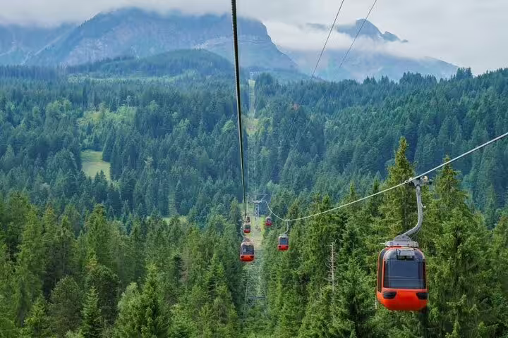 Scenic cable cars traverse green landscapes of Mount Pilatus, perfect for a Lucerne private daily excursion.