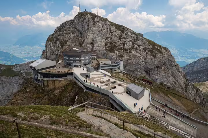 Panoramic view of Mount Pilatus summit station with stunning mountainous landscape and observation deck.