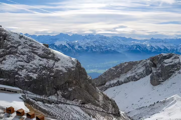 Majestic snowy peaks and expansive vistas of the Swiss Alps as seen from Mount Pilatus during a serene winter day.