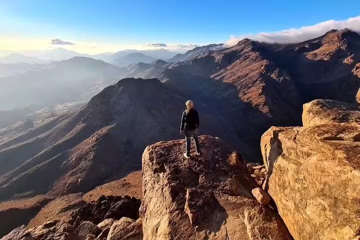 Hiker on Mount Sinai summit viewpoint, private Sharm El Sheikh climb with sweeping Sinai mountain scenery