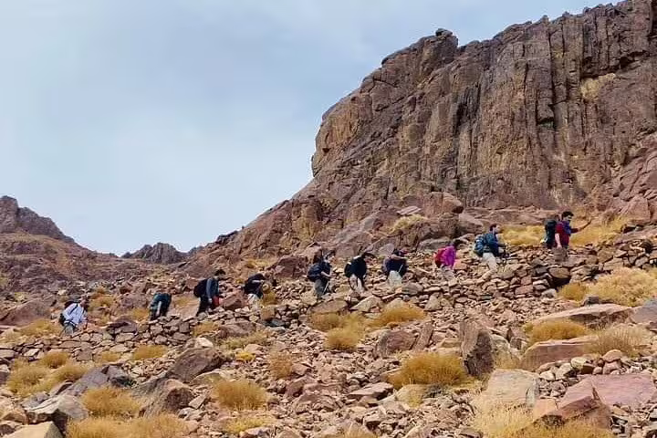 Group trekking rocky trail on Mount Sinai sunrise climb from Sharm El Sheikh, route to St Catherine Monastery