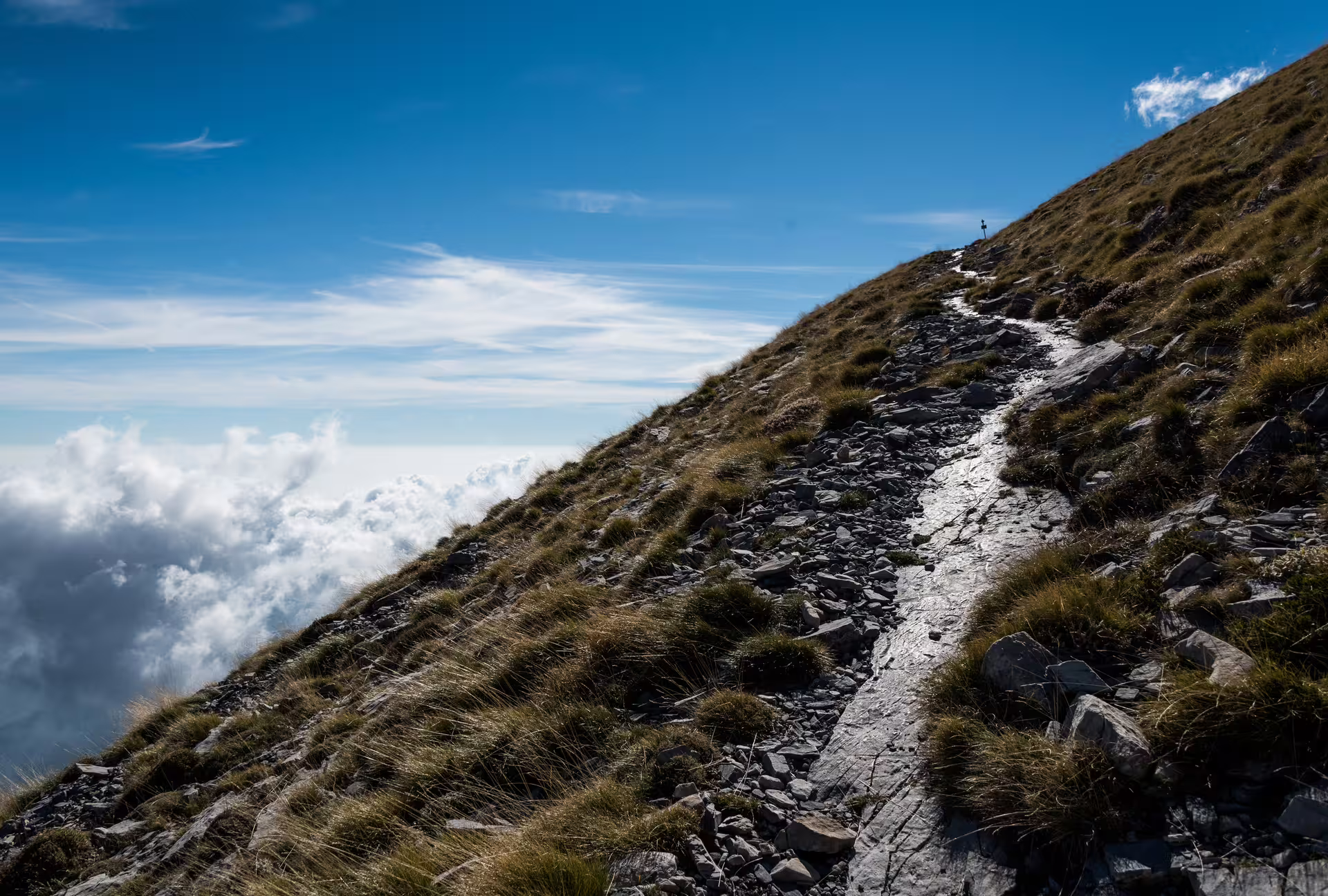 Rocky mountain trail climbing to Mount Taygetos summit 2407m, Greece, high-altitude hike with cloud views