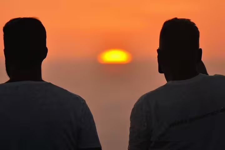 Silhouetted figures enjoying a breathtaking sunset view at Mount Teide, perfect for stargazing and dinner experiences.