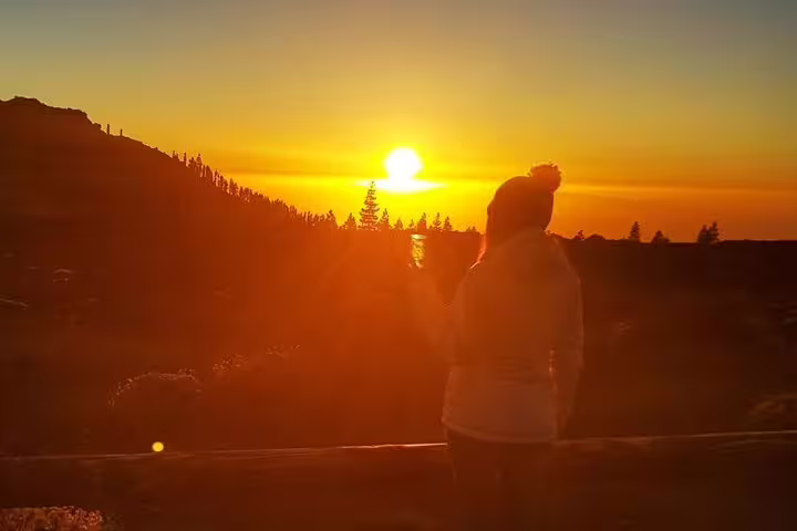 Silhouette of a person watching a breathtaking sunset at Mount Teide, highlighting the beauty of Tenerife's skies.