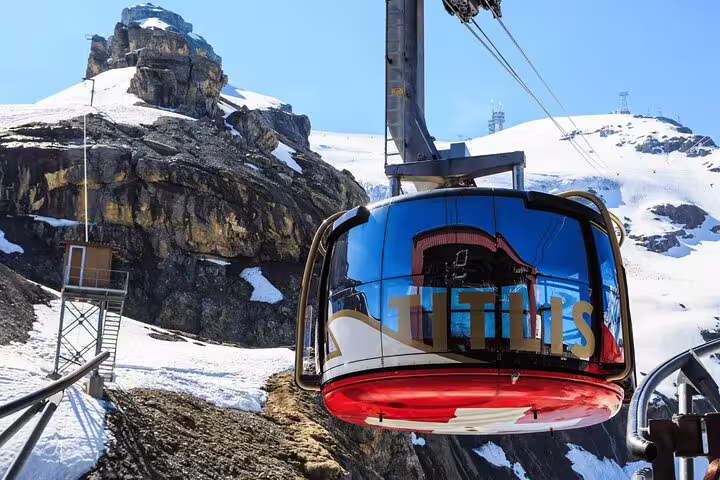 Panoramic view of Mount Titlis cable car ride, showcasing snow-capped peaks and pristine alpine scenery.