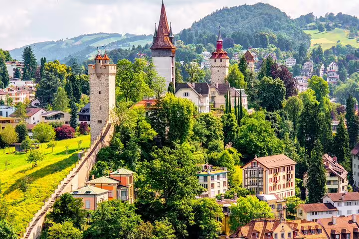 Stunning view of Museggmauer towers nestled among lush greenery in Lucerne, a highlight of Mount Titlis day trips.