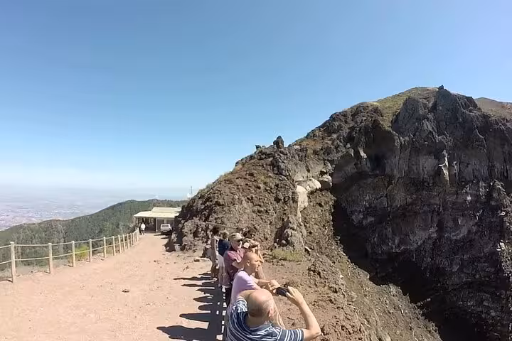 Tourists capturing views at the edge of Mount Vesuvius crater on the Pompeii and Vesuvius Skip-The-Line Tour.