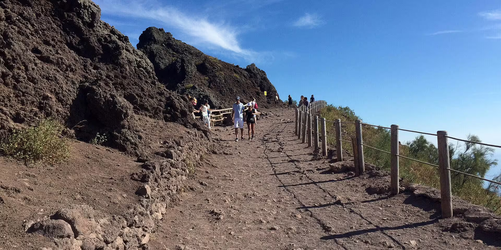 Hikers on the Mount Vesuvius trail near Naples, guided group tour path with volcanic rocks and views
