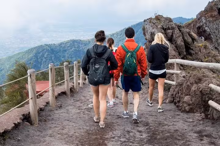 Tourists hiking the scenic trail on Mount Vesuvius with panoramic views, part of the Vesuvius Experience tour.