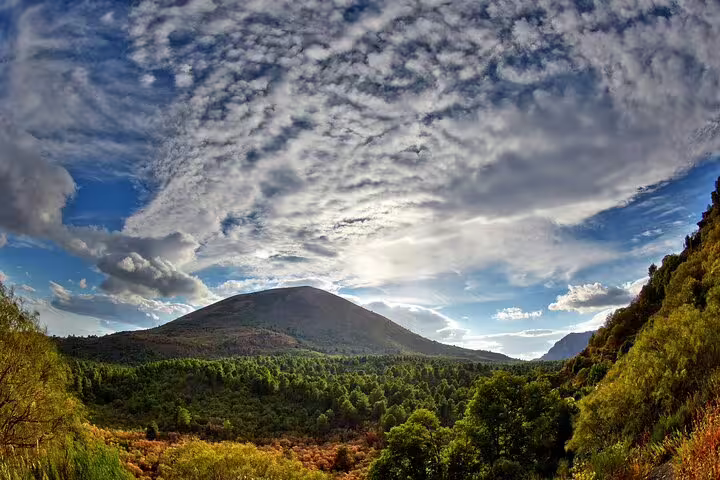 Mount Vesuvius landscape view over green forest under dramatic clouds on VIP small-group tour with ticket