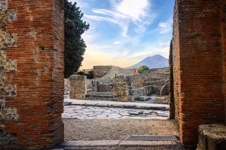 View of Mount Vesuvius through ancient ruins in Pompeii, capturing the historical essence on this tour from Positano.