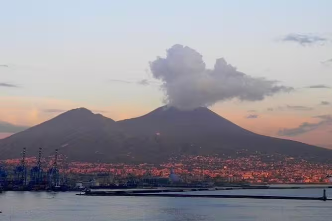 Mount Vesuvius smoking above Naples Bay at sunset, scenic view on Pompeii and Vesuvius group tour from Naples