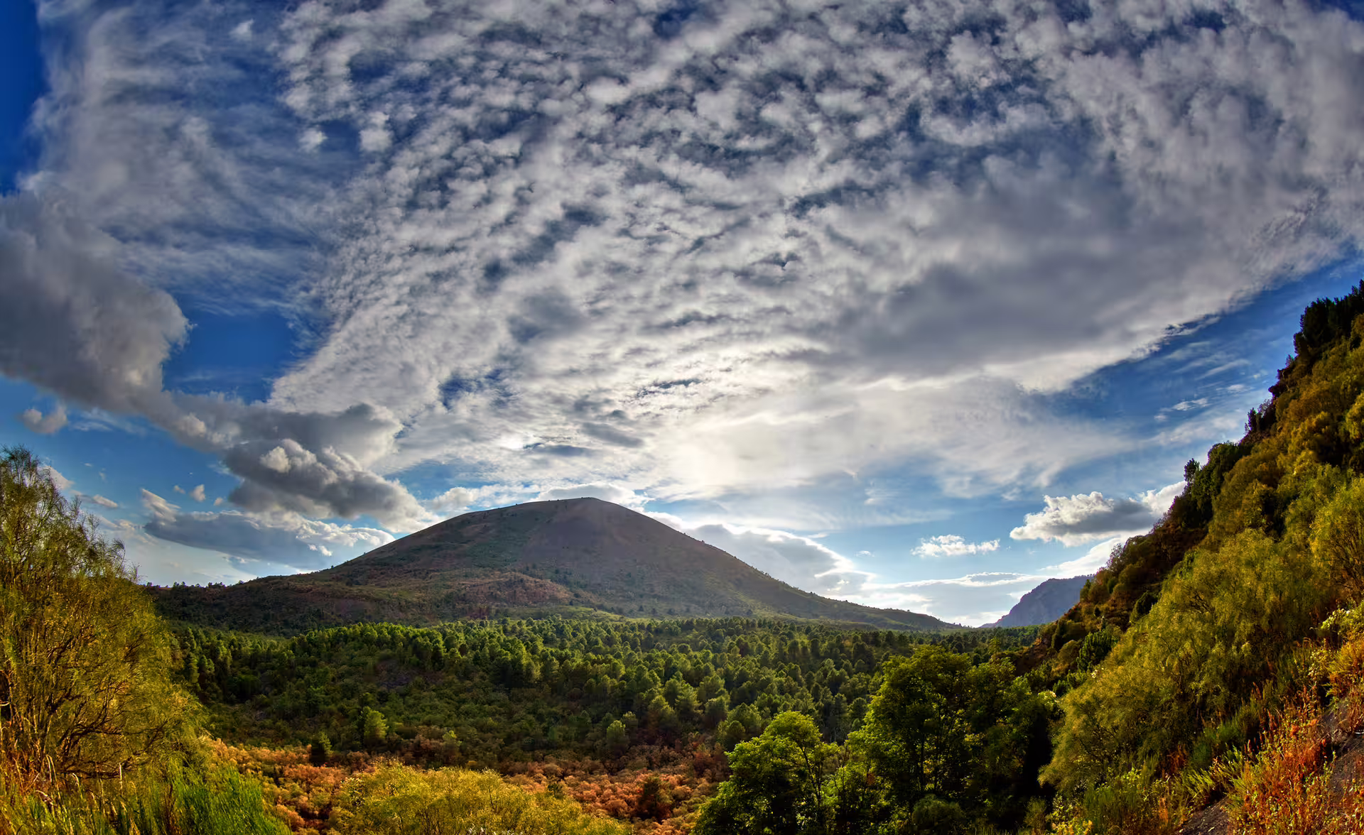 Scenic view of Mount Vesuvius slopes under dramatic clouds, budget Vesuvius tour from Naples