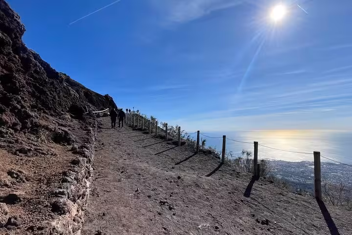 Scenic view of Mount Vesuvius trail with sunlit sky, perfect for hiking from Amalfi Coast to Pompeii and Vesuvius.