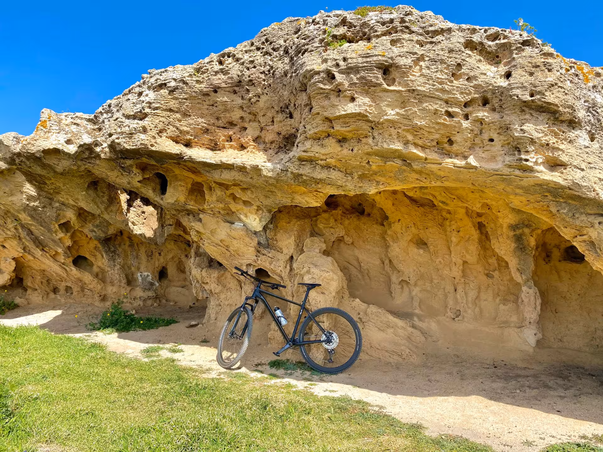 Mountain bike parked by unique rock formations on the Sinis Peninsula bike tour from Oristano.