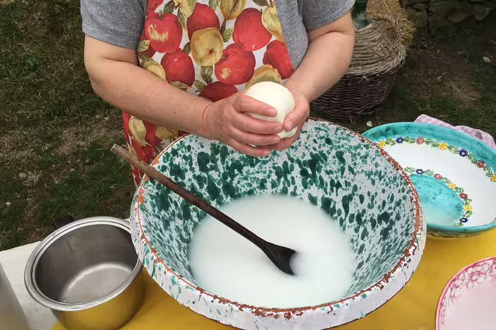 Hands shaping fresh mozzarella during farm tour cheese workshop before pizza, wine tasting and limoncello test