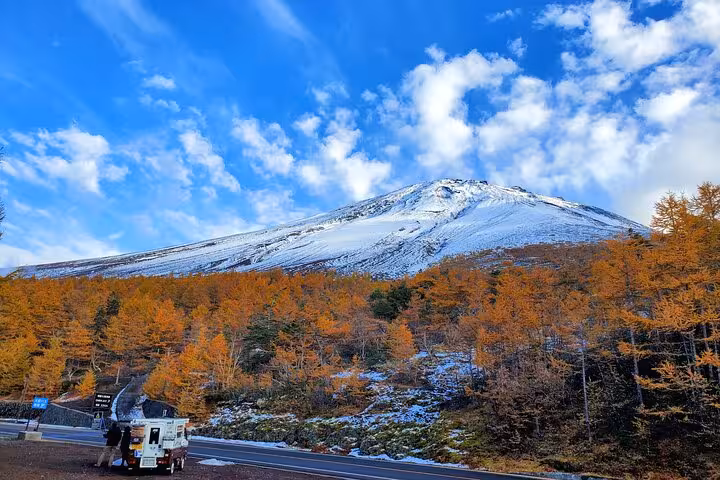 Snow-capped Mt. Fuji with vibrant autumn foliage, ideal for photography during the English Guided 2 Days Mt. Fuji Tour.