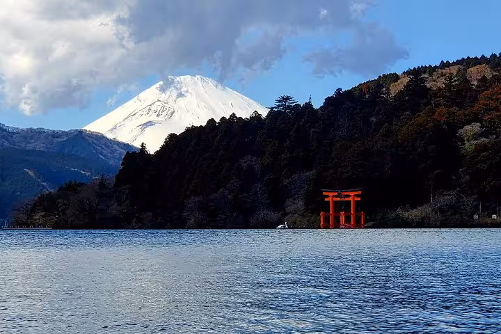 Scenic view of Mt. Fuji with a red torii gate on Lake Ashi, highlighting the beauty of Hakone's natural landscapes.