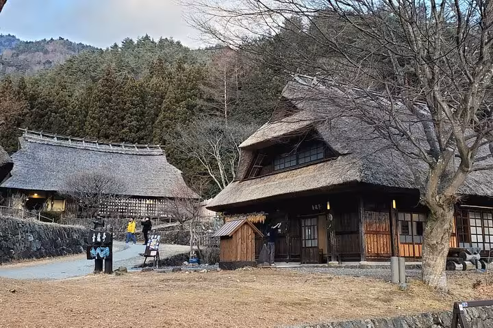 Traditional thatched-roof houses in a serene village setting on the Mt. Fuji and Hakone private tour.