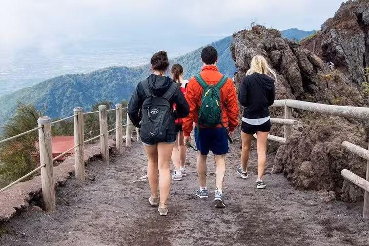 Group of hikers walking along a scenic trail on Mt. Vesuvius with panoramic views, perfect for adventure seekers.