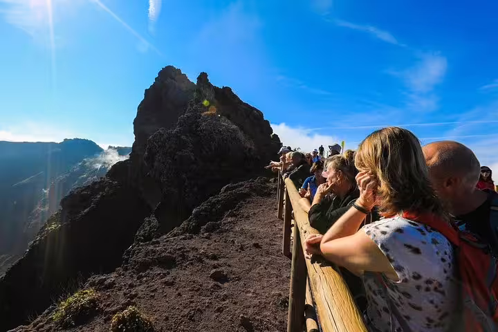 Tourists admire the breathtaking view from the edge of Mt. Vesuvius on a clear day during a guided tour from Sorrento.